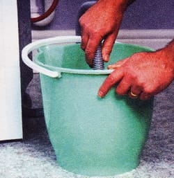 дренажният маркуч от машината се спуска в празна кофа